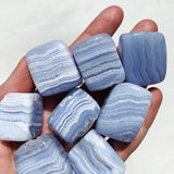 a hand holding Blue Lace Agate Tumbled crystals
